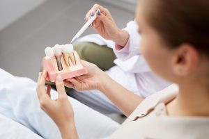 patient holding a dental implant model